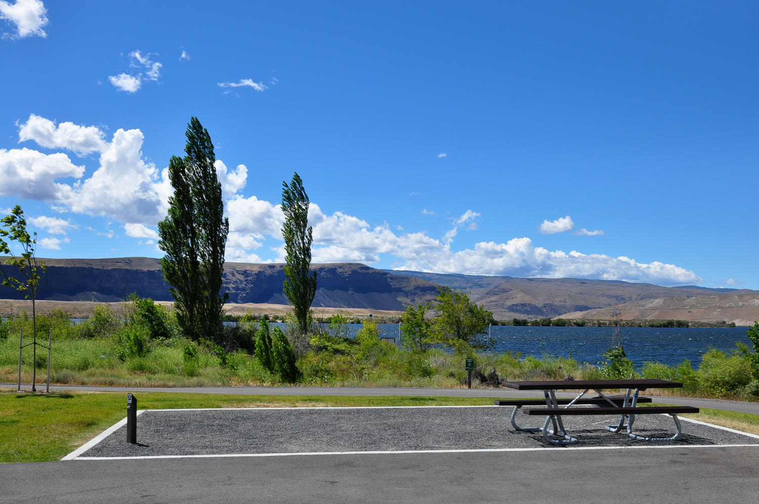Paved campsite with picnic table by the river